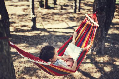 Hamakta kitap okuyarak istirahat kadın