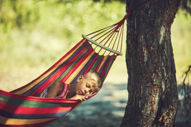 Hamakta, bahçede oturan çocuk oynarken komik küçük çocuk