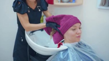 Kapatmak yukarıya-in yüz güzel kadının Kuaför tarafından bir hairwash oluyor.