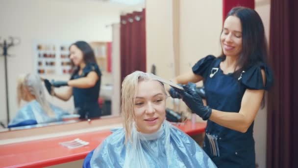 プロの美容師が彼女のクライアントの髪を染める — ストック動画
