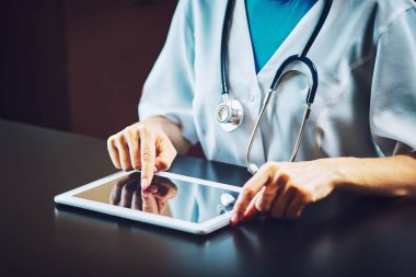 Hastanede tablet bilgisayar kullanan kadın doktor.