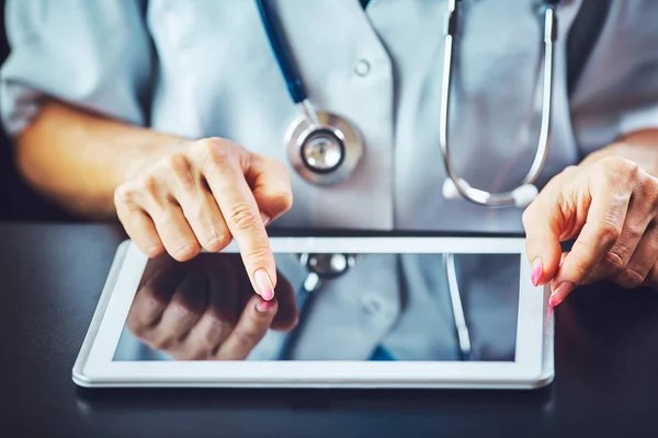 Hastanede tablet bilgisayar kullanan kadın doktor.