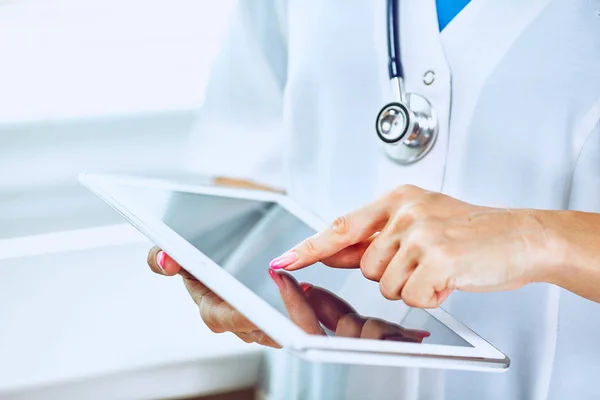 Hastanede tablet bilgisayar kullanan kadın doktor.