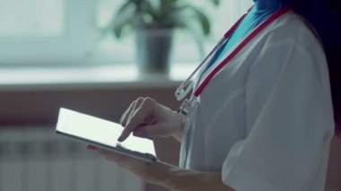 Hastanede tablet bilgisayar kullanan kadın doktor.