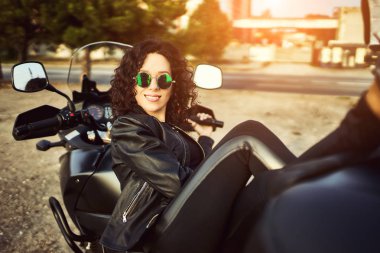 Genç kadın şehir içinde motosiklet Binme. Bir motosiklet ile güzel bir kadın portresi