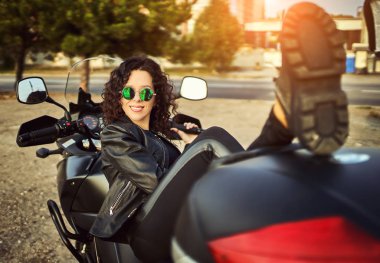 Genç kadın şehir içinde motosiklet Binme. Bir motosiklet ile güzel bir kadın portresi