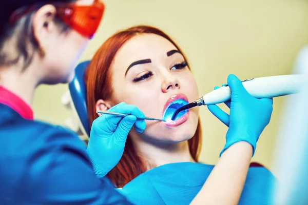 口腔内の歯科重合ランプで働く歯科医 — ストック写真