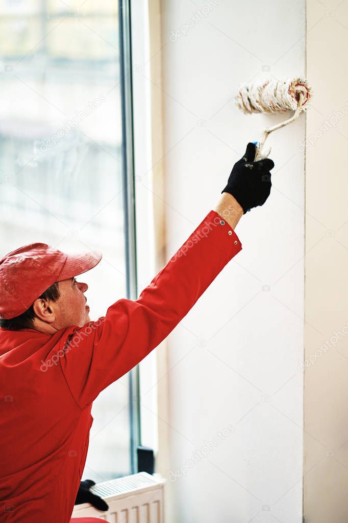 The worker in special clothes makes repair of the apartment.