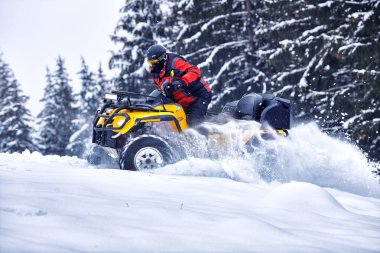 Ormanda kışın dört tekerlekli bisiklete binen sürücü.