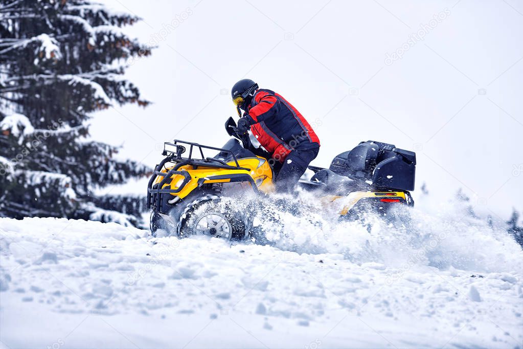 Rider driving in the quadbike race in winter in the forest