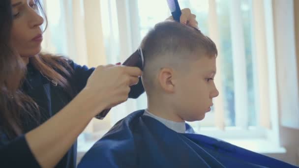 Hairdresser cutting hair with barber scissors in children hairdressing salon. — Stock Footage Hairdresser Cutting Hair Barber Scissors Children Hairdressing Salon Video Clip