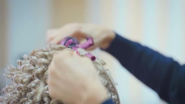 美容院で長い金髪を持つかなり若い女性に髪形をしている笑顔の女性美容師 — ストック動画