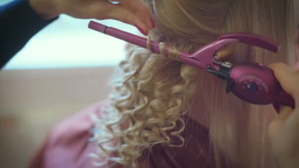 美容院で長い金髪を持つかなり若い女性に髪形をしている笑顔の女性美容師 — ストック動画