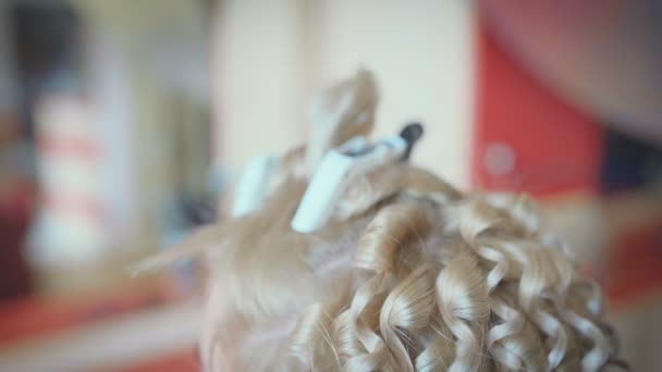 微笑的女理发师做发型漂亮的年轻女子与长的金发在美发沙龙 — 图库视频影像