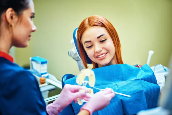 歯科医院での患者様の人工顎を示す女性歯科医 — ストック写真