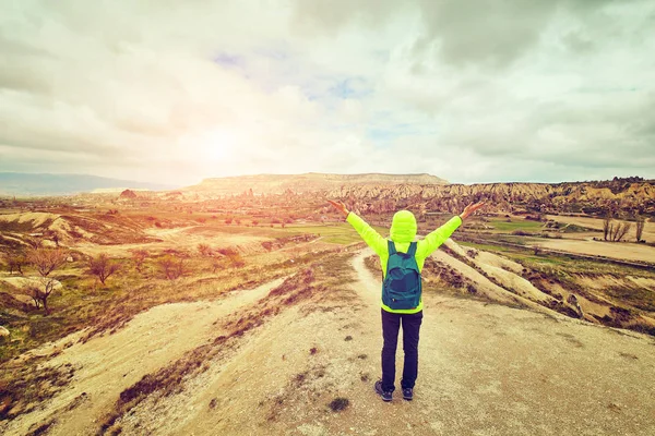 Mujer viajera levantó las manos descubriendo montañas con mochila — Foto de Stock