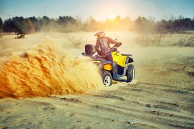 Kum tepeleri içinde Atv sürme Genç kum bir dönüş yapma