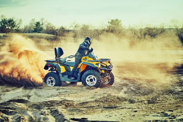 Tiener rijden ATV in zandduinen het maken van een bocht in het zand — Stockfoto