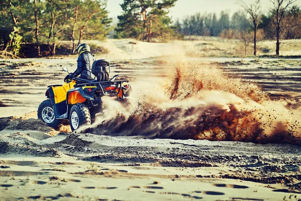 Tonåring ridning ATV i sanddyner gör en sväng i sanden — Stockfoto
