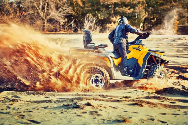 Tiener rijden ATV in zandduinen het maken van een bocht in het zand — Stockfoto