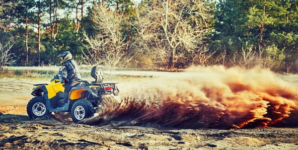 Tiener rijden ATV in zandduinen het maken van een bocht in het zand — Stockfoto