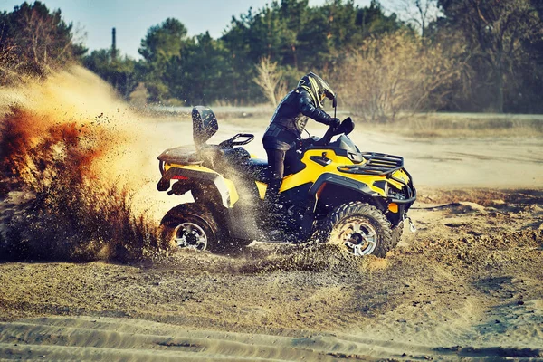 Teen Reiten atv in Sanddünen machen eine Wendung im Sand — Stockfoto