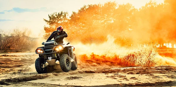 Tiener rijden ATV in zandduinen het maken van een bocht in het zand — Stockfoto