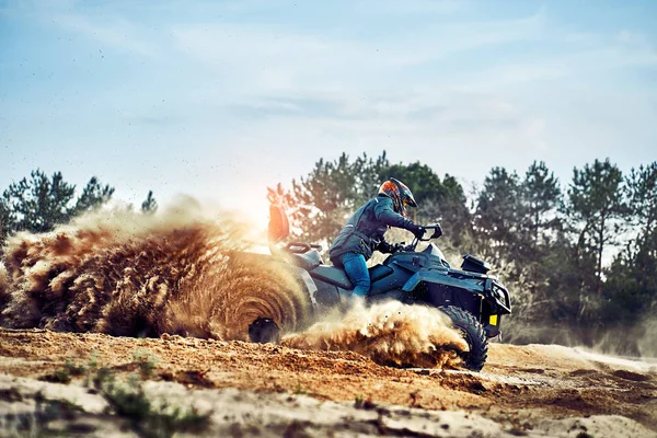 Tonåring ridning ATV i sanddyner gör en sväng i sanden — Stockfoto