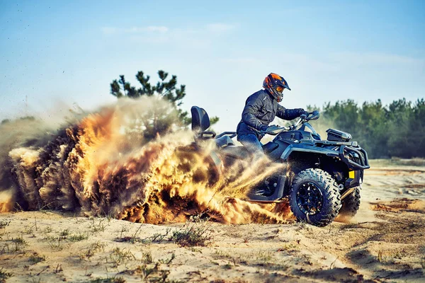 Adolescente cabalgando ATV en dunas de arena haciendo un giro en la arena — Foto de Stock