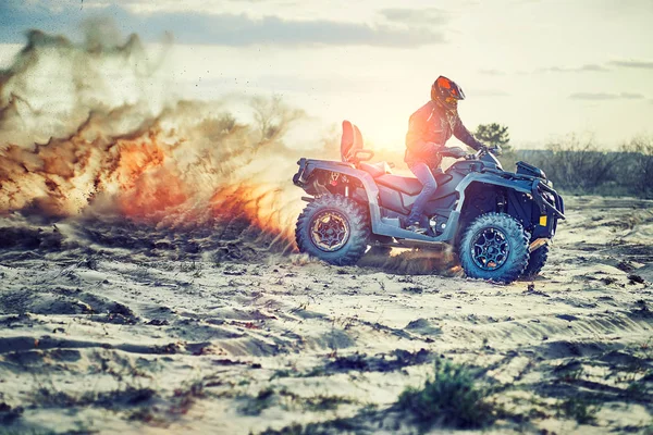 Teen riding ATV in sand dunes making a turn in the sand — Stock Photo, Image