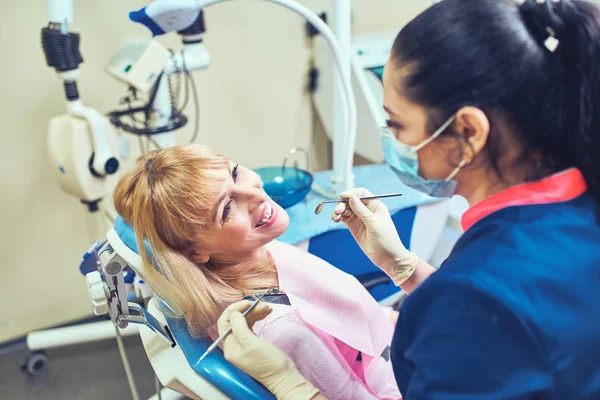 Dentista che esamina i denti di un paziente dal dentista . — Foto Stock