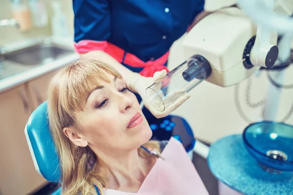 Dentista examinando los dientes de un paciente en el dentista . — Foto de Stock