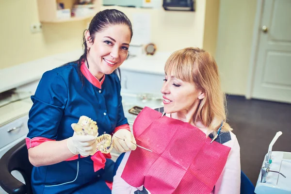 Dentista examinando los dientes de un paciente en el dentista . — Foto de Stock