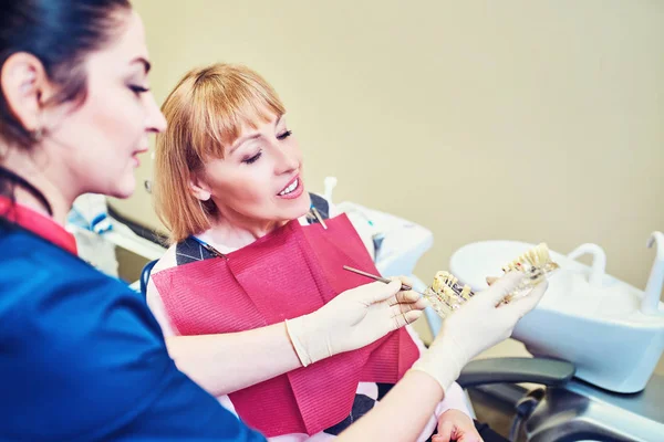 Dentista examinando los dientes de un paciente en el dentista . — Foto de Stock