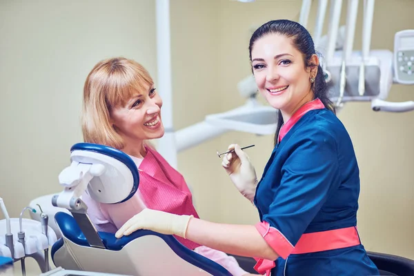 Dentista examinando los dientes de un paciente en el dentista . — Foto de Stock