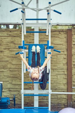 Neşeli çocuk spor ekipmanları üzerinde egzersiz yapıyor.