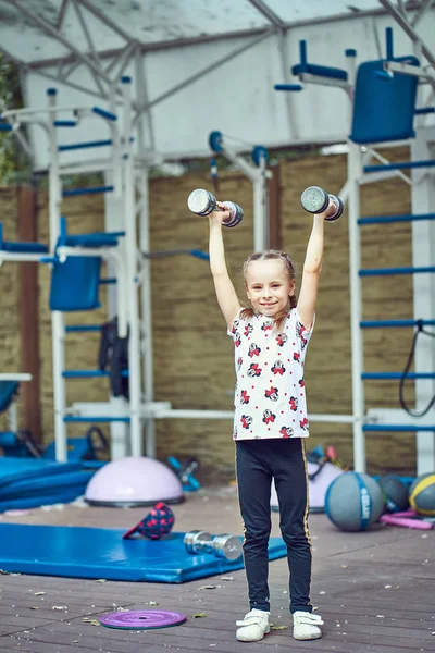 Bambino allegro che fa esercizi su attrezzature sportive . — Foto Stock