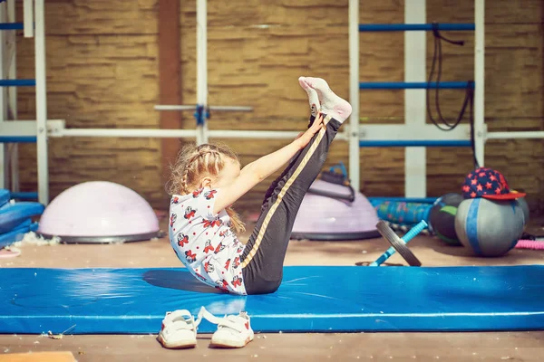 Cheerful child doing exercises on sports equipment. — Stock Photo, Image
