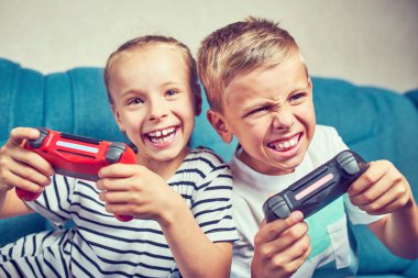 Çocuklar couc üzerinde otururken duygusal bir video oyunu oynamak