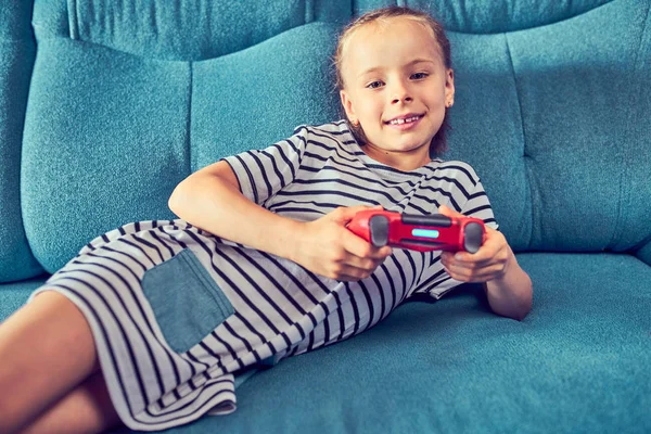 Дети эмоционально играют в видеоигру, сидя на кубе — стоковое фото
