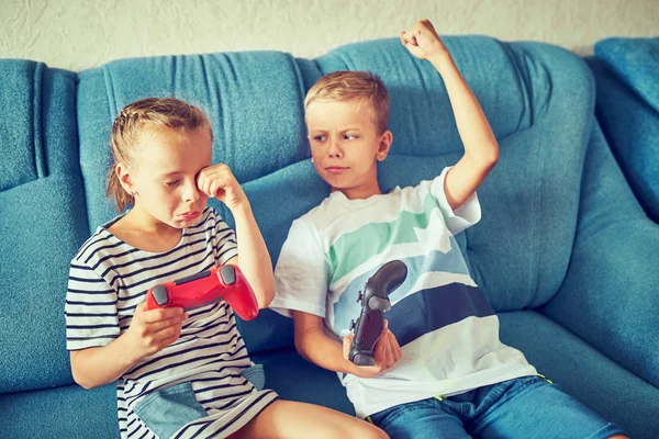 बच्चे भावनात्मक रूप से एक वीडियो गेम खेलते हैं जबकि कूप पर बैठे हैं — स्टॉक फ़ोटो, इमेज