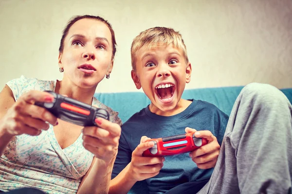 Молодые мама и сын играют в видеоигры — стоковое фото