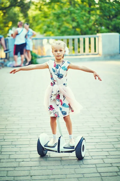 Девушка ездит верхом на ховерборде по дорожкам парка — стоковое фото