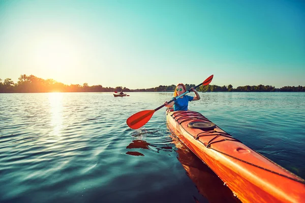 Les gens kayak pendant le coucher du soleil en arrière-plan. Amusez-vous dans votre f — Photo