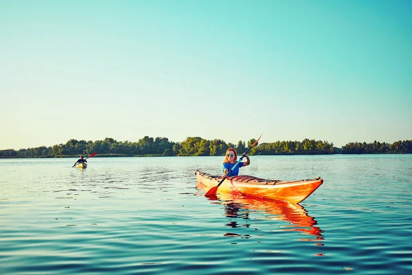 Les gens kayak pendant le coucher du soleil en arrière-plan. Amusez-vous dans votre f — Photo