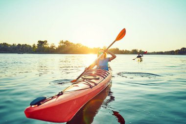 İnsanlar arka planda gün batımında kano. F içinde eğlenin