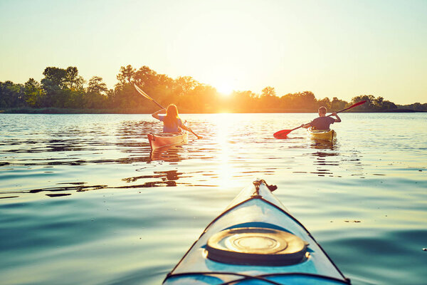 People kayak during sunset in the background. Have fun in your f