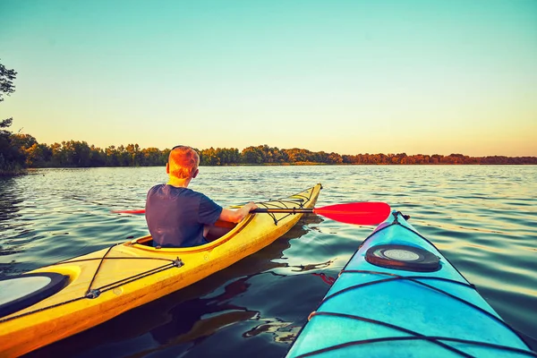 Les gens kayak pendant le coucher du soleil en arrière-plan. Amusez-vous dans votre f — Photo