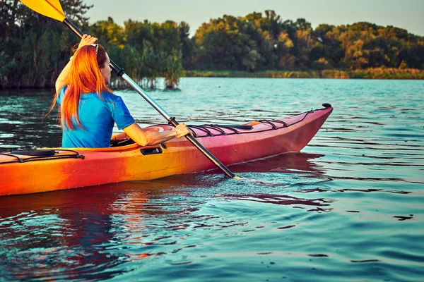 La gente kayak durante la puesta del sol en el fondo. Diviértete en tu f — Foto de Stock