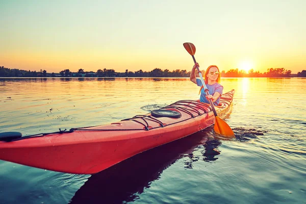 La gente kayak durante la puesta del sol en el fondo. Diviértete en tu f — Foto de Stock